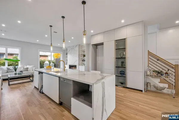 a kitchen with stainless steel appliances kitchen island granite countertop a sink a stove and a wooden floors