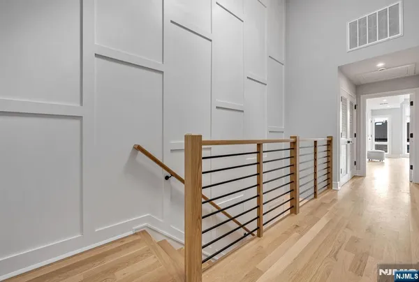 a view of a hallway with wooden floor and stairs