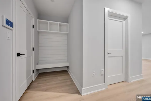 a view of a hallway with wooden floor and closet area