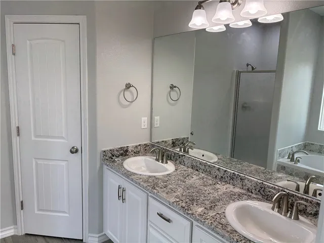 a bathroom with a granite countertop sink a light fixture and a mirror