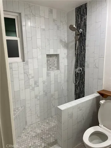 a bathroom with a toilet and a shower