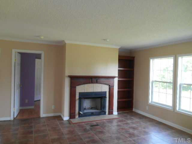 1353 Pixley Pritchard Road Timberlake, NC 27583 - Photo 9 of 12 an empty room with a fireplace and window