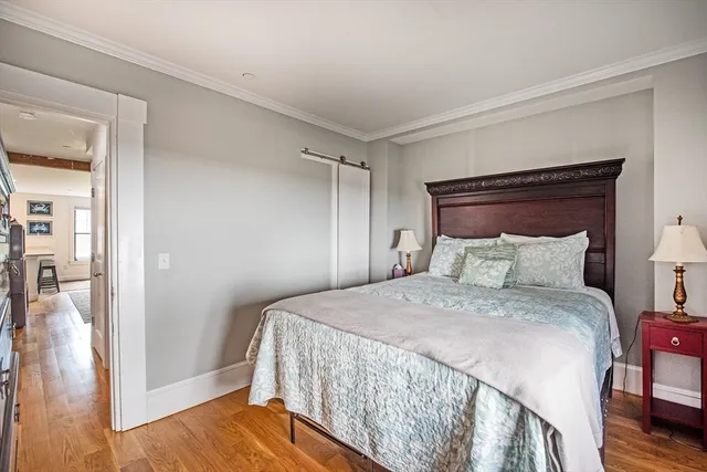 a bedroom with a bed and wooden floor
