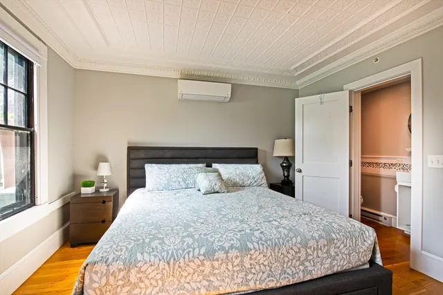 a bedroom with a bed and wooden floor