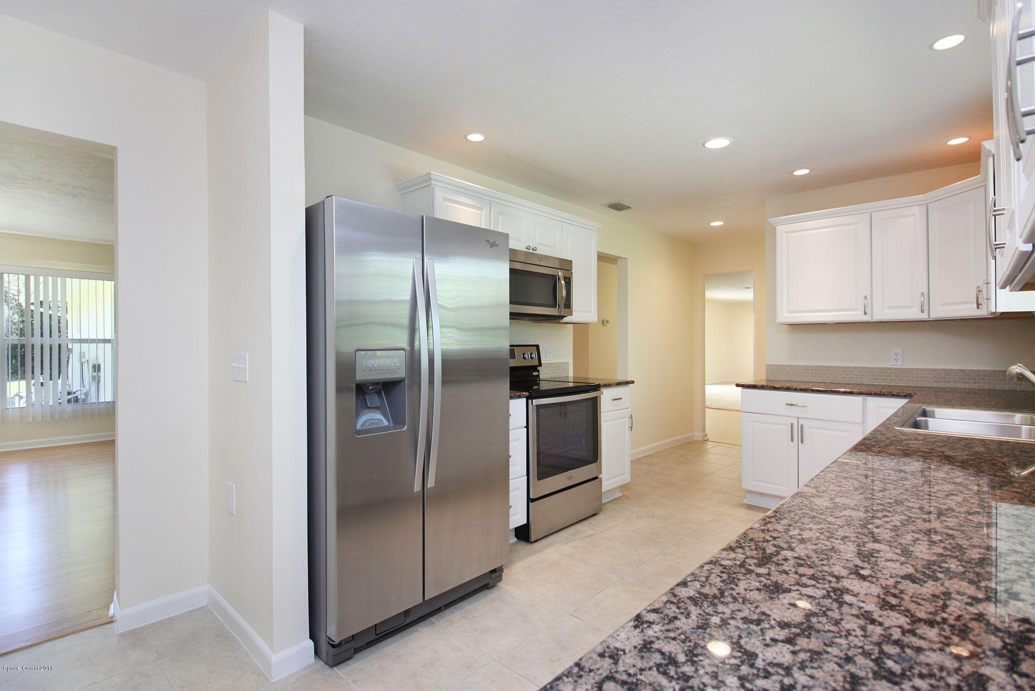 4521 Mustang Road Melbourne, FL 32934 - Photo 11 of 24 a kitchen with stainless steel appliances granite countertop a refrigerator and a sink