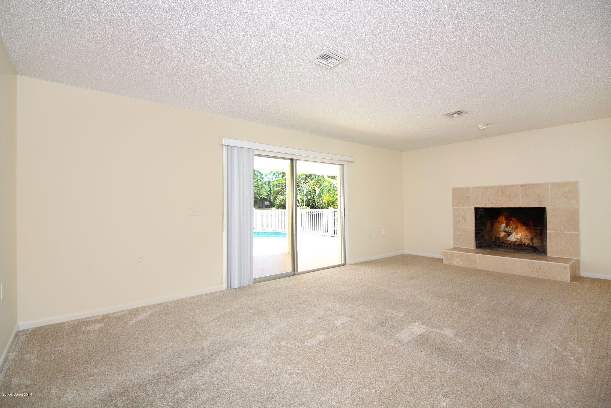 4521 Mustang Road Melbourne, FL 32934 - Photo 12 of 24 a view of an empty room with a window and a fireplace