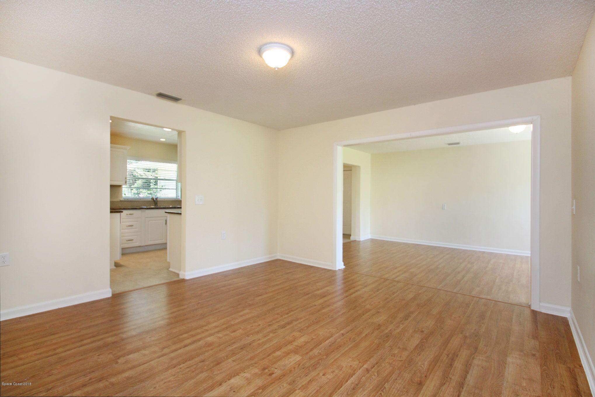 4521 Mustang Road Melbourne, FL 32934 - Photo 14 of 24 an empty room with wooden floor and windows