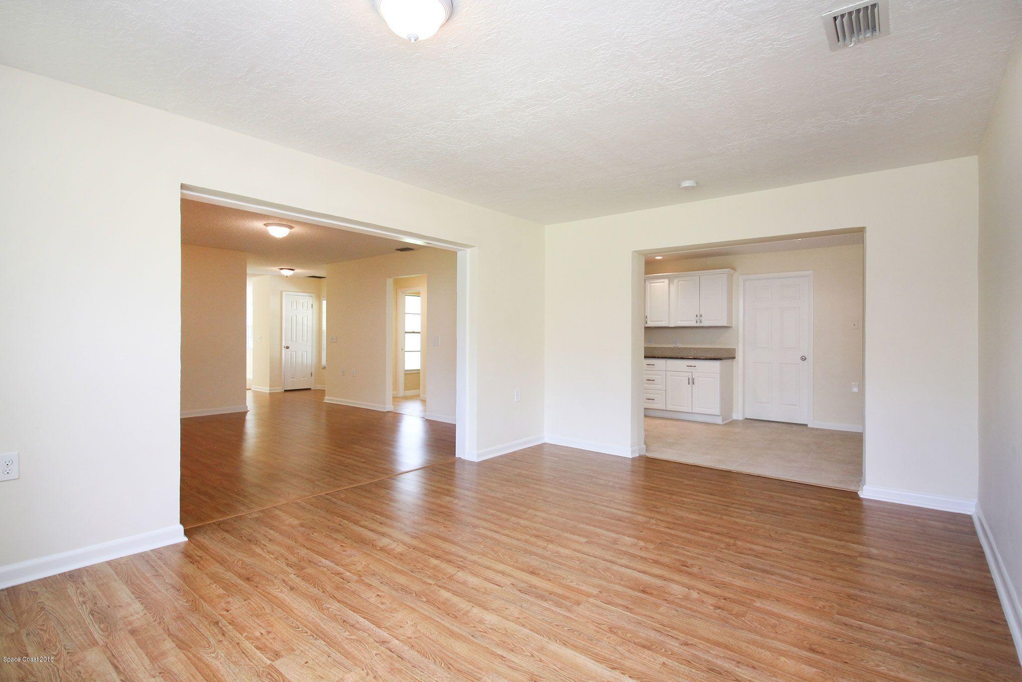 4521 Mustang Road Melbourne, FL 32934 - Photo 15 of 24 a view of an empty room with wooden floor and a window