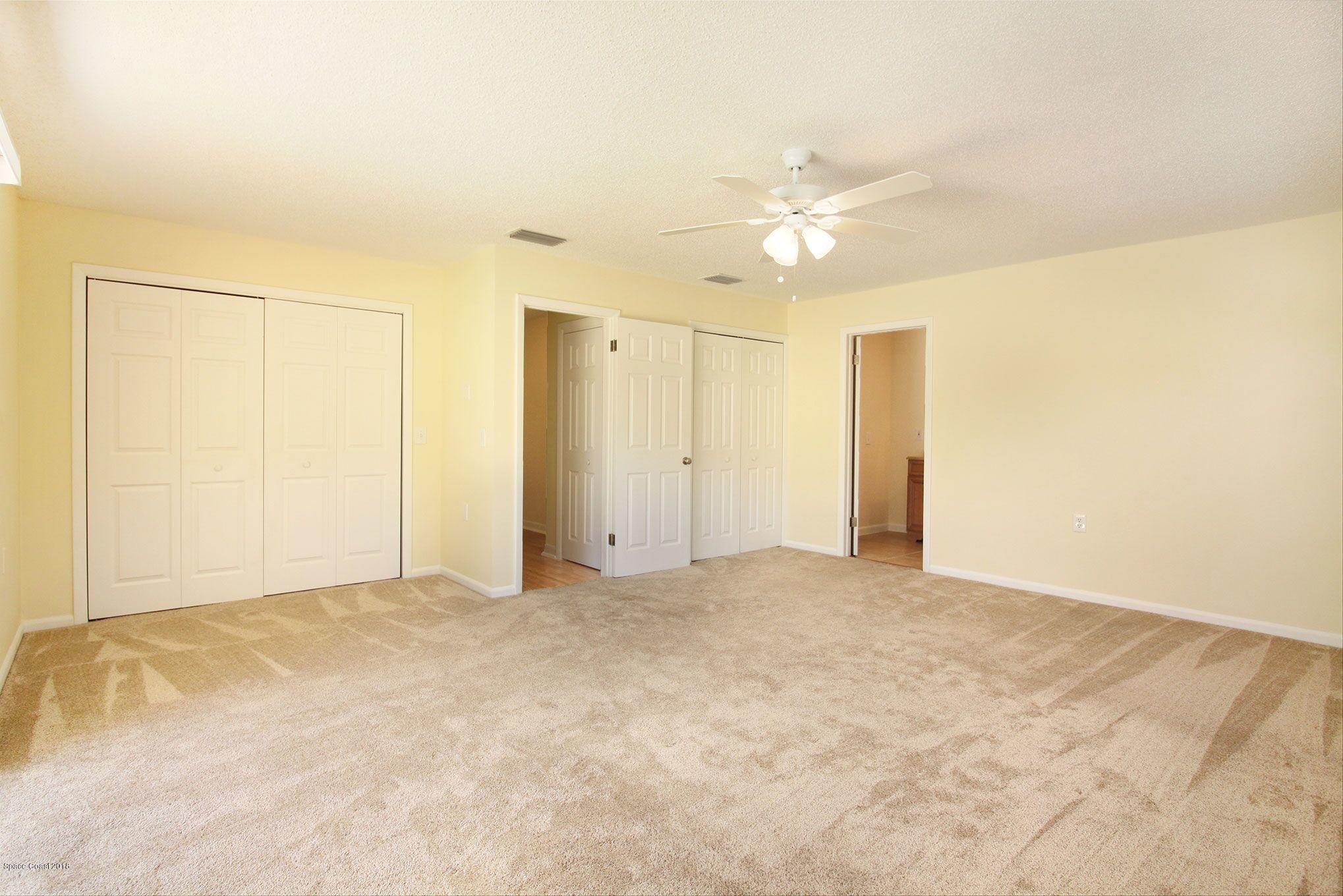 4521 Mustang Road Melbourne, FL 32934 - Photo 18 of 24 an empty room with a ceiling fan and a window