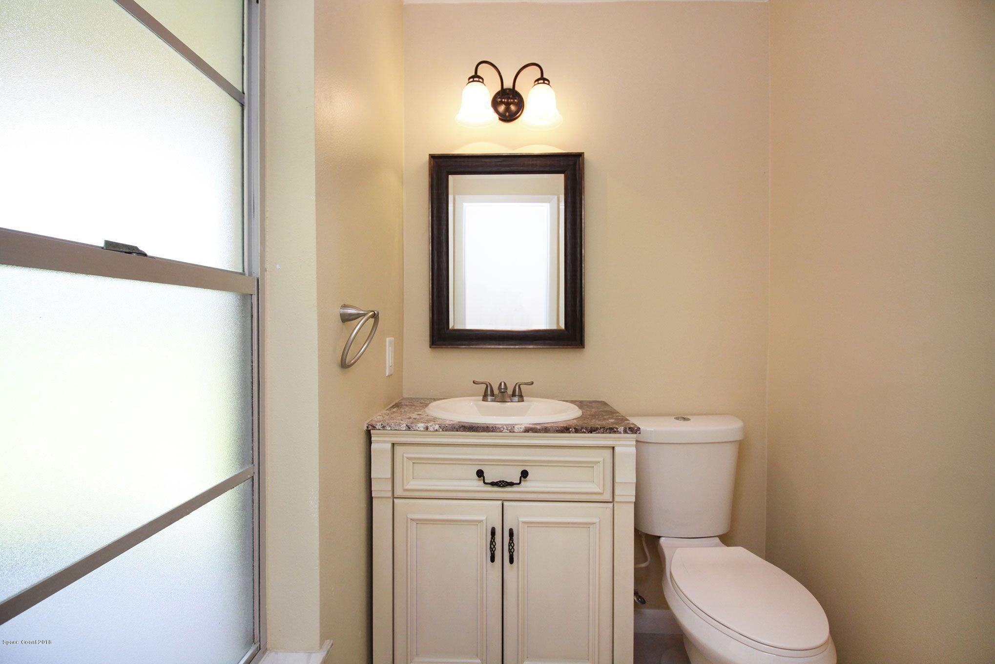 4521 Mustang Road Melbourne, FL 32934 - Photo 24 of 24 a bathroom with a toilet sink and mirror