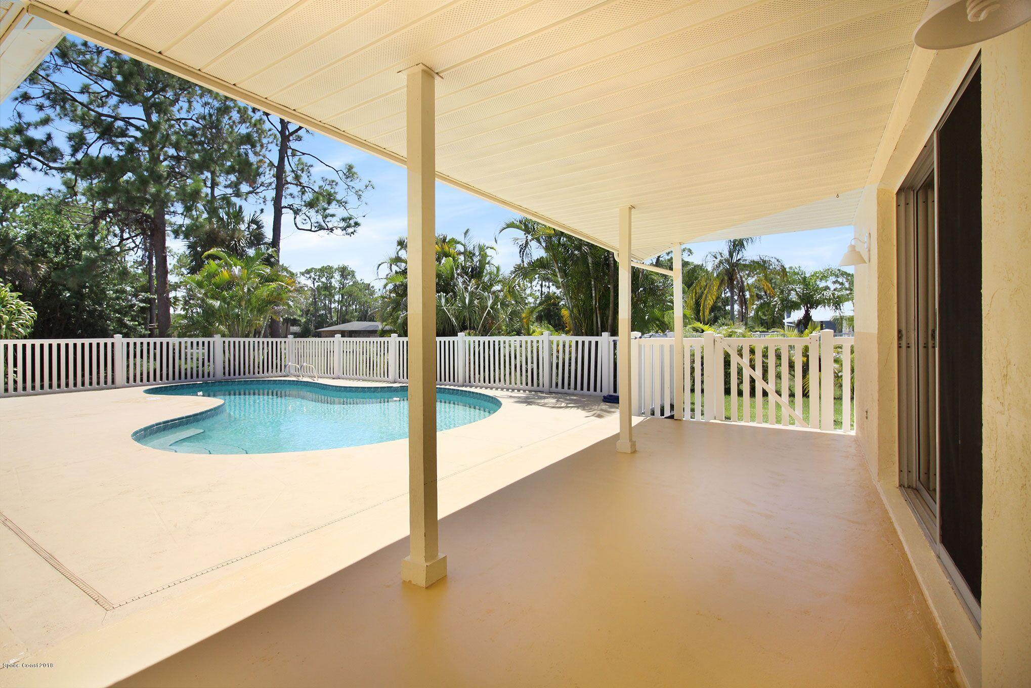 4521 Mustang Road Melbourne, FL 32934 - Photo 9 of 24 a view of a deck with a big yard potted plants and floor to ceiling window
