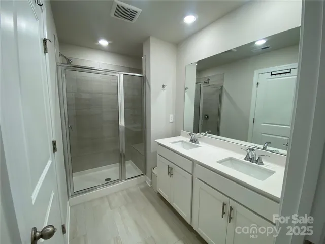 a bathroom with a shower sink and mirror