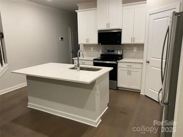 a kitchen with stainless steel appliances a stove microwave and sink