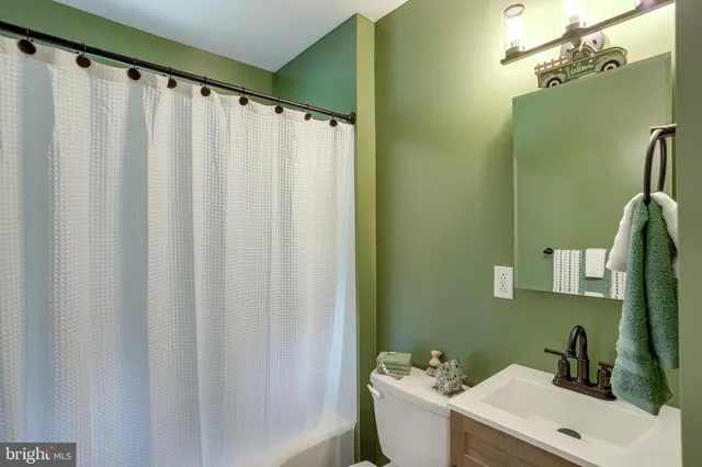 a bathroom with a sink a toilet and mirror