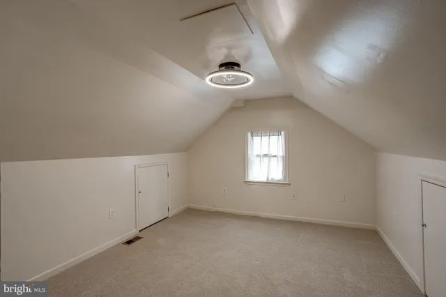 an empty room with a window and chandelier fan
