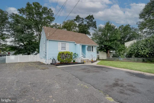 a view of a house with backyard and bushes