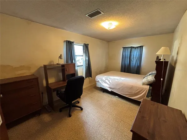 a bedroom with a bed chair and piano