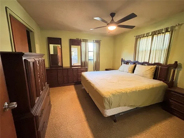 a bedroom with a bed next to a window