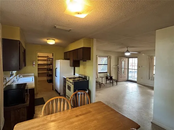 a living room with furniture a flat screen tv and kitchen view
