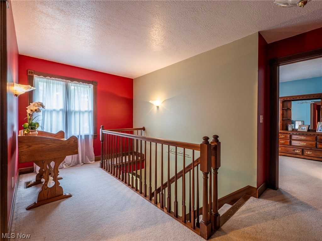 9452 Pleasant Hill Road Northwest Dundee, OH 44624 - Photo 27 of 35 Stairs featuring light carpet and a textured ceiling