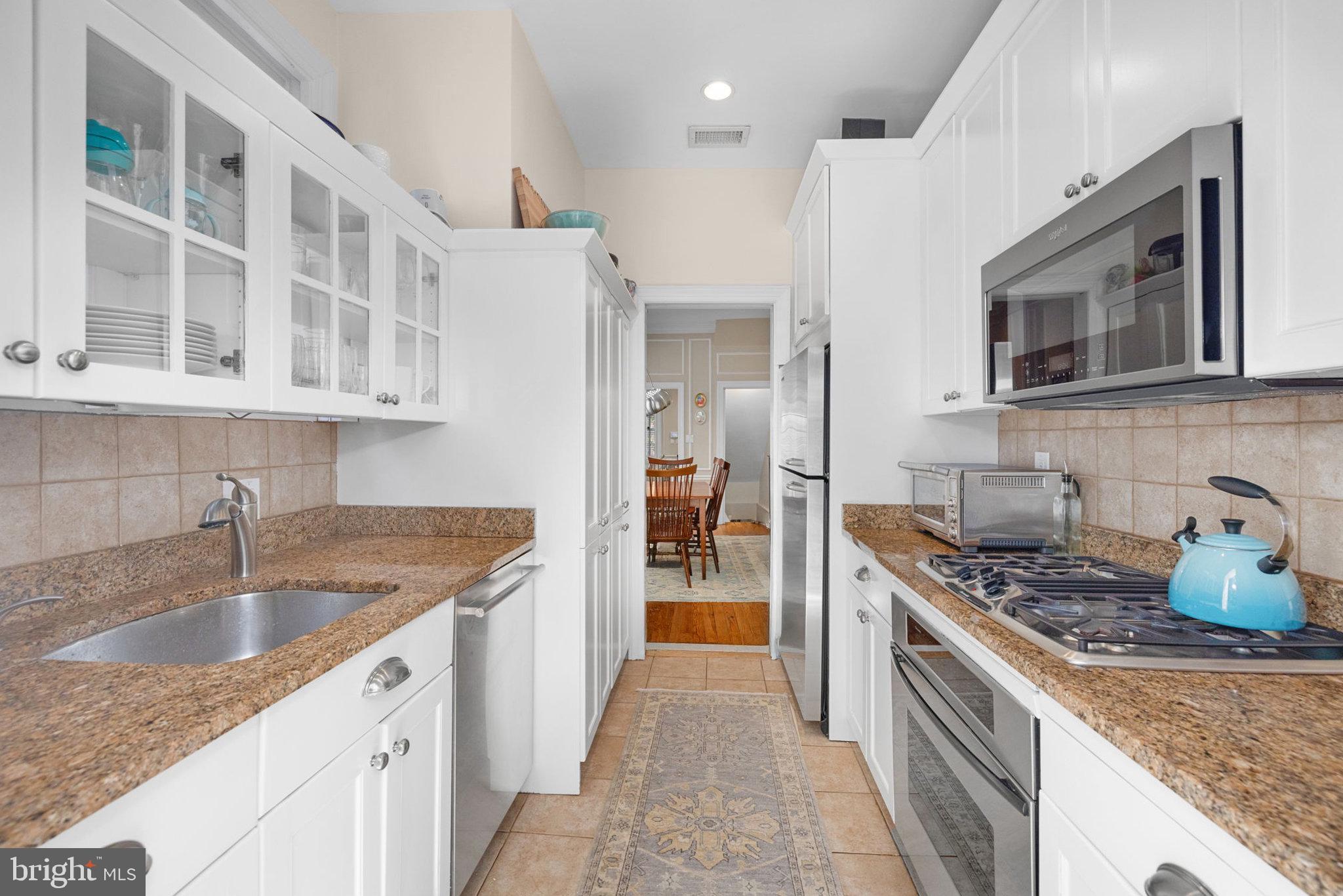 3104 N Street Northwest Washington, DC 20007 - Photo 8 of 25 a kitchen with stainless steel appliances granite countertop a sink stove and refrigerator
