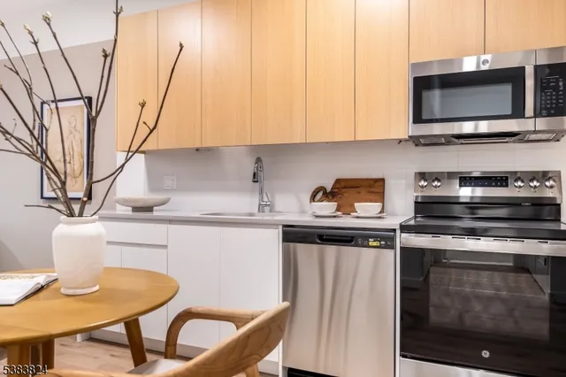 a kitchen with stainless steel appliances a stove a sink microwave and cabinets