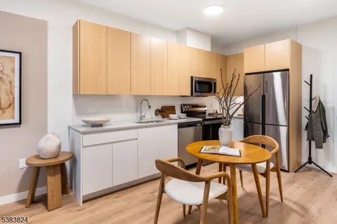 a kitchen with a refrigerator a stove a sink and chairs