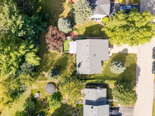 an aerial view of a house with a swimming pool a yard and a fountain