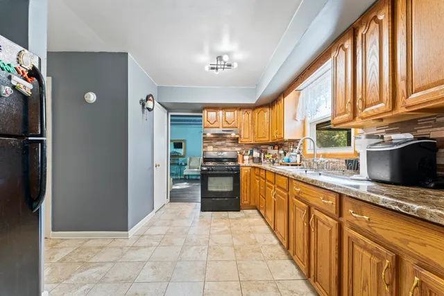 a kitchen with stainless steel appliances granite countertop a refrigerator and a sink