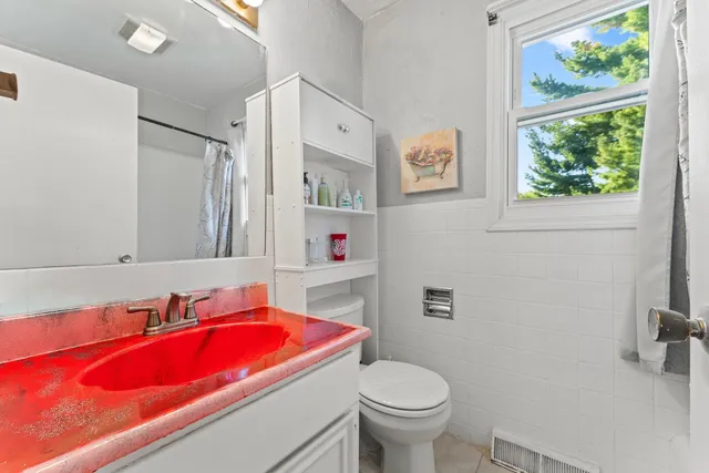 a bathroom with a granite countertop toilet sink and mirror