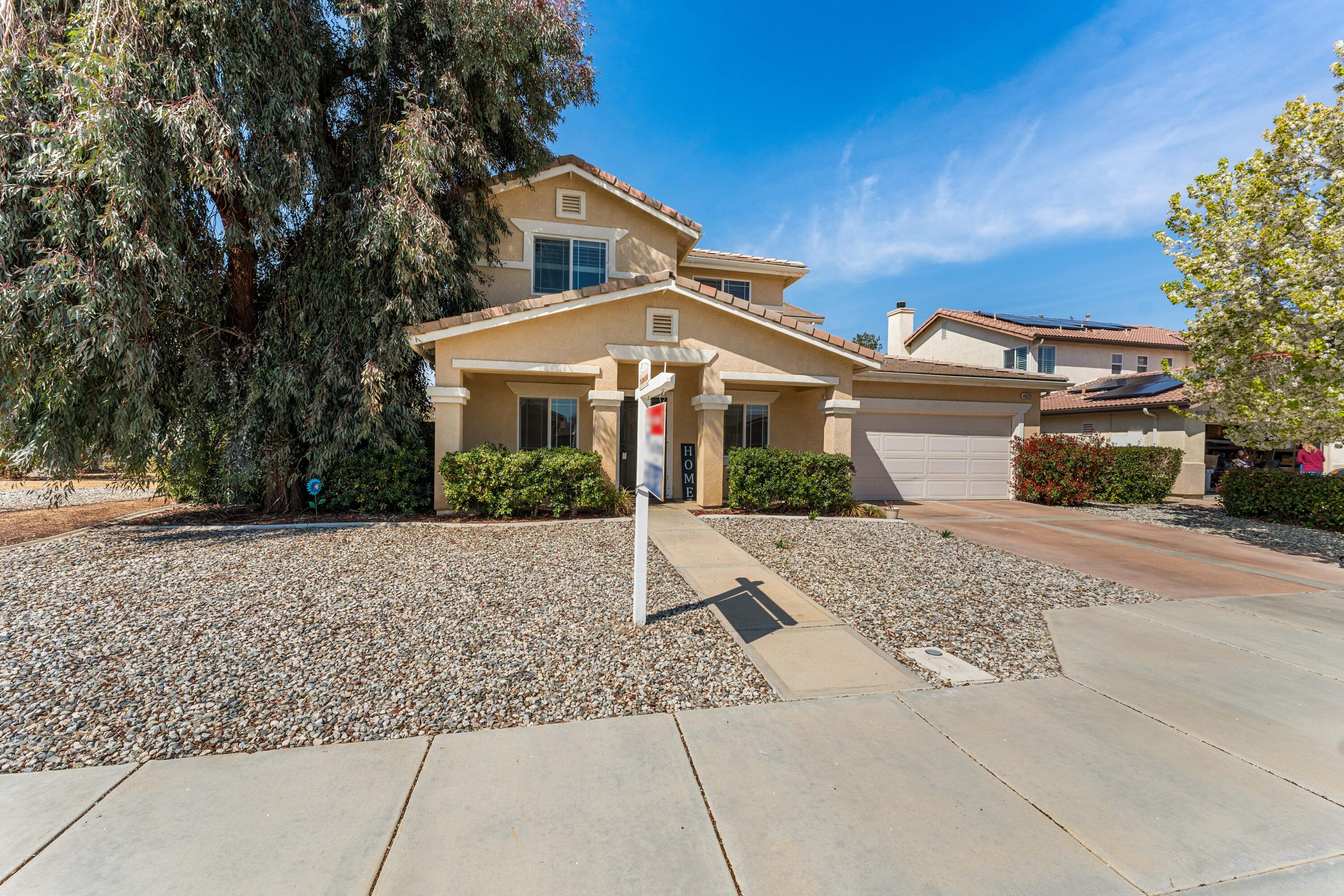 44225 Rucker Street Lancaster, CA 93535 - Photo 2 of 16 a front view of a house with a yard and garage