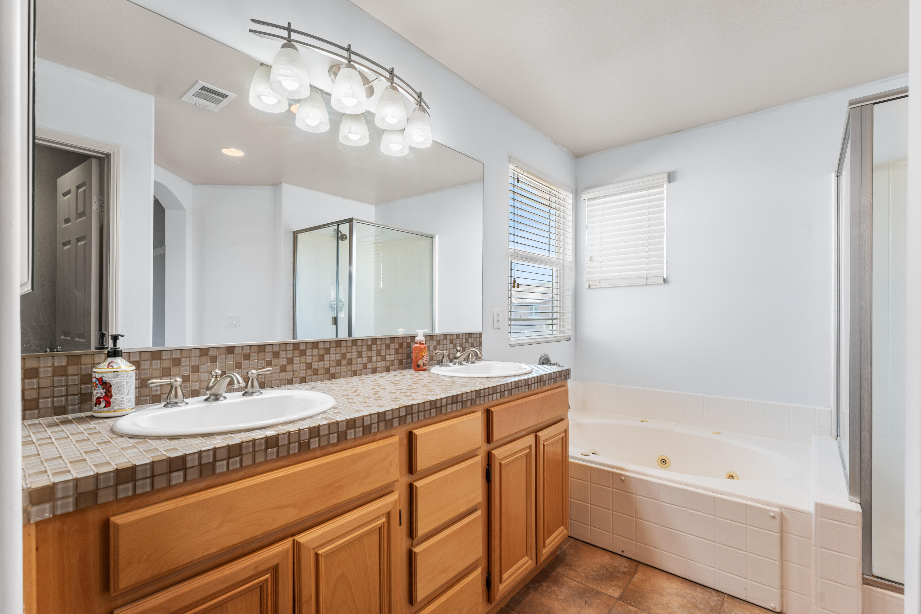 44225 Rucker Street Lancaster, CA 93535 - Photo 10 of 16 a bathroom with a tub a sink and mirror