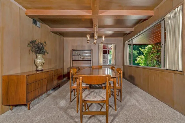 a bedroom with a large bed chandelier and a window