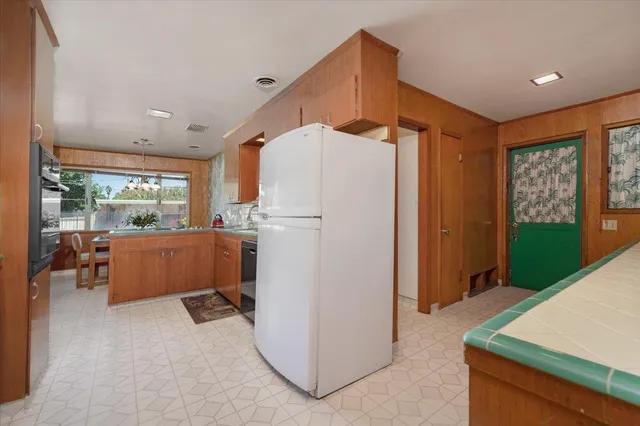 a kitchen with stainless steel appliances granite countertop a refrigerator and a stove top oven