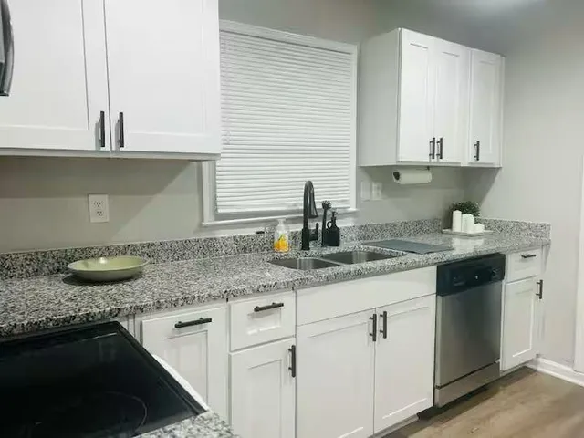 a kitchen with granite countertop a sink and a stove