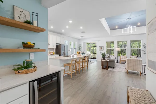 a kitchen with stainless steel appliances a stove a sink a refrigerator cabinets and a dining table
