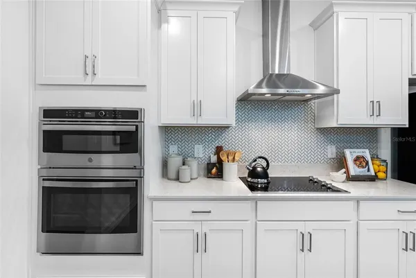 a kitchen with white cabinets and appliances