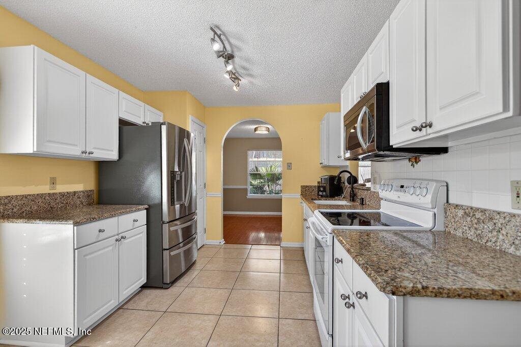 2472 Moon Harbor Way Middleburg, FL 32068 - Photo 3 of 52 a kitchen with stainless steel appliances granite countertop a sink stove and refrigerator