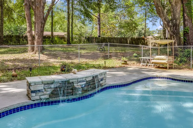 a view of a swimming pool with a patio and a yard