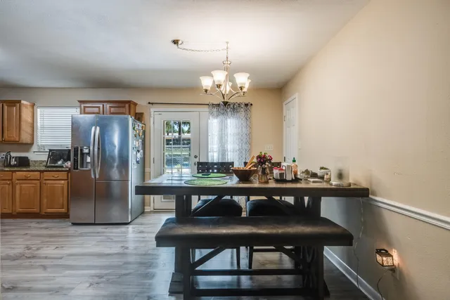 a view of a dining room with furniture wooden floor and a chandelier