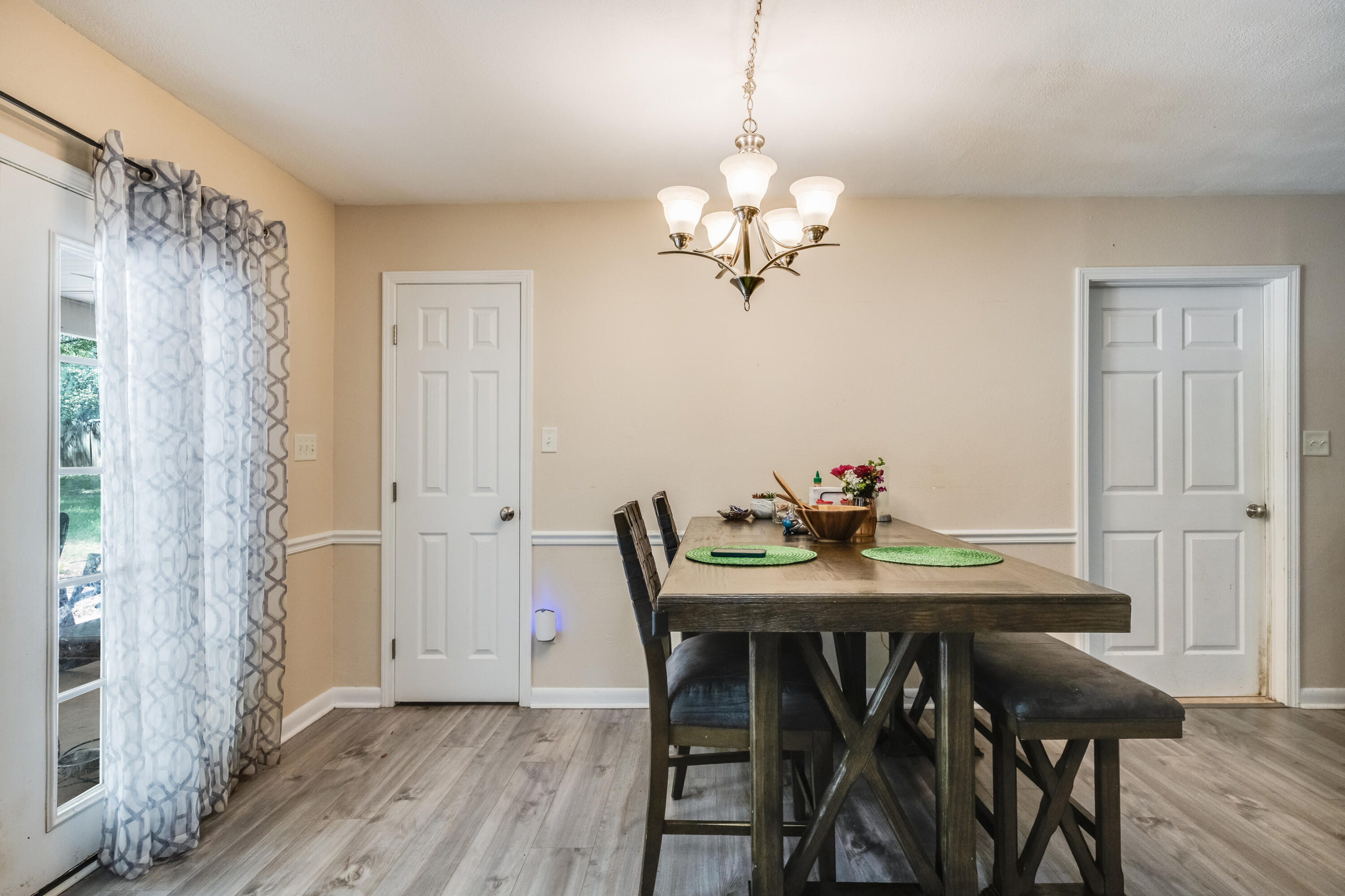 6633 Frank Reeder Road Pensacola, FL 32526 - Photo 26 of 43 a view of a dining room with furniture wooden floor and a chandelier