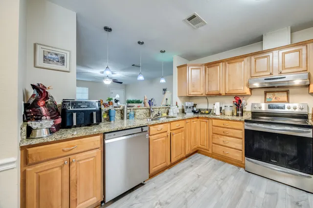 a kitchen with granite countertop a refrigerator and a sink