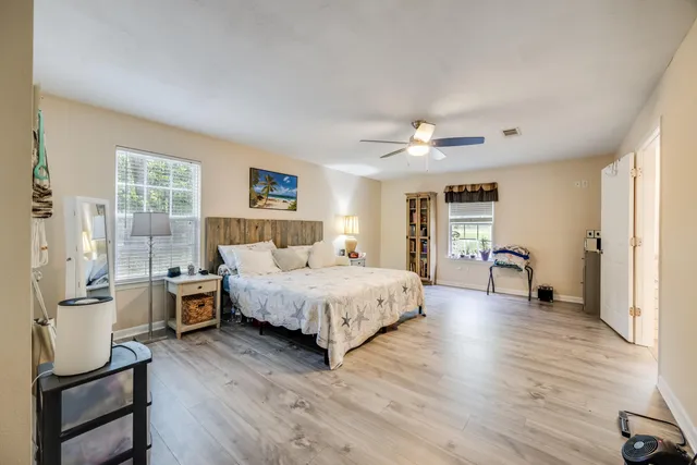 a bedroom with a large bed and wooden floor