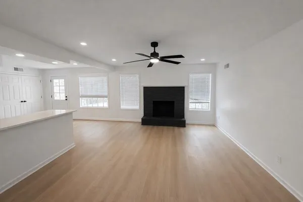 a view of an empty room with a fireplace and a window