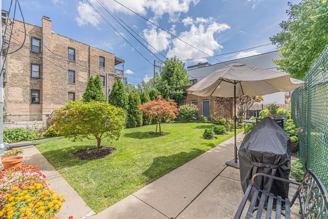 a view of a patio with a table and chairs under an umbrella