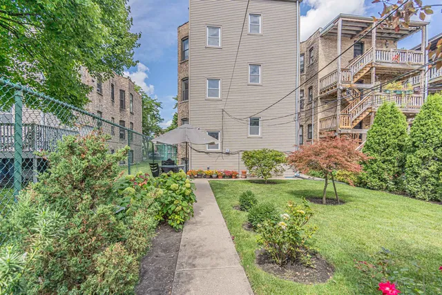 a view of a brick house with a yard and plants