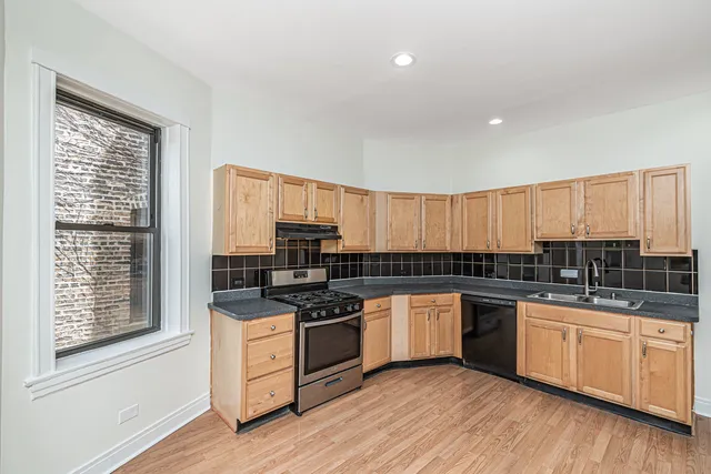 a kitchen with appliances a sink and cabinets