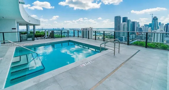 a view of a swimming pool with a patio and a yard