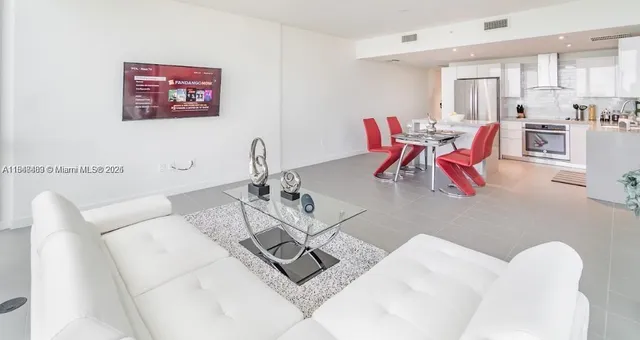 a living room with furniture and kitchen view