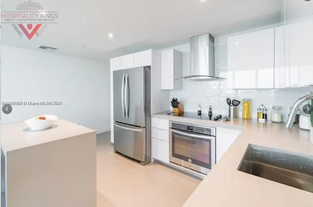a kitchen with stainless steel appliances granite countertop a refrigerator sink and stove